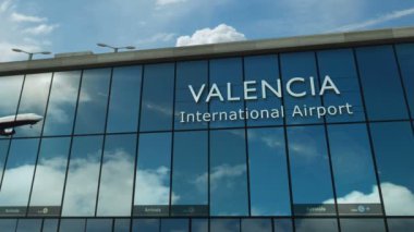 Valencia, İspanya 'ya uçak iniyor. Cam havaalanı terminali ve jet uçağının yansımasıyla şehre vardık. Seyahat, iş, turizm ve ulaşım 3D konsepti.