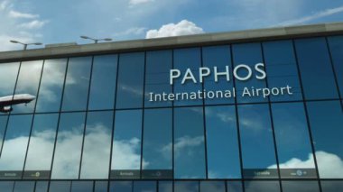 Kıbrıs, Paphos 'a uçak iniyor. Cam havaalanı terminali ve jet uçağının yansımasıyla şehre vardık. Seyahat, iş, turizm ve ulaşım 3D konsepti.