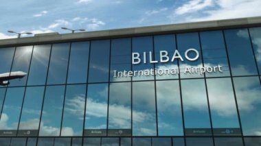 İspanya, Bilbao 'ya uçak iniyor. Cam havaalanı terminali ve jet uçağının yansımasıyla şehre vardık. Seyahat, iş, turizm ve ulaşım 3D konsepti.
