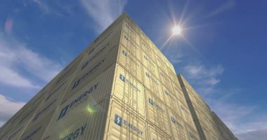 Liman terminali iş konseptinde enerji depolama konteynerleri. Batarya istasyonlu nakliye kutusu. Gökyüzü ve güneş zamanı doluyor.