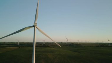 Rüzgâr türbinleri gün batımında buğday tarlasında duran bir rüzgar parkının havadan görüntüsü. - Evet. Yüksek kalite 4k görüntü