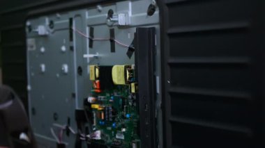 Tamirci, hasar gören noktayı bulmak için çoklu sayaç kullanarak bir TV veya diğer ev aletlerini tamir eder. Yüksek kalite 4k görüntü