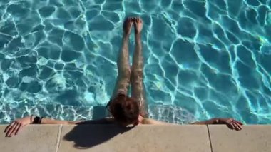 Sıcak bir yaz gününde, havuz kenarında mavi suda bir kadına karşı. Yüksek kalite 4k görüntü