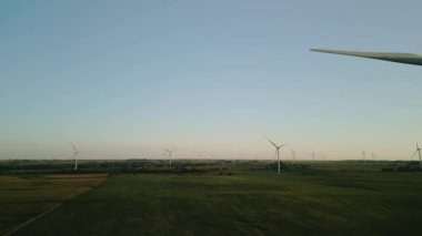 Rüzgâr türbinleri gün batımında buğday tarlasında duran bir rüzgar parkının havadan görüntüsü. - Evet. Yüksek kalite 4k görüntü