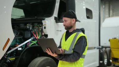 Teknik merkezde ya da depoda aracın servisi, dizüstü bilgisayardaki kamyon hakkındaki bilgileri kaydediyor. Yüksek kalite 4k görüntü