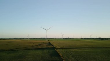 Rüzgâr türbinleri gün batımında buğday tarlasında duran bir rüzgar parkının havadan görüntüsü. - Evet. Yüksek kalite 4k görüntü