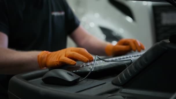 一位戴着手套在维修车间工作的男工在键盘上的电脑上写字 高质量的4K镜头 — 图库视频影像