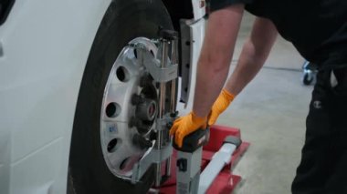 Tamirci, kamyonetteki tekerlekleri bir tamirhanenin hizalama tezgahında duruyor. Yüksek kalite 4k görüntü