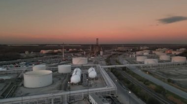 Alacakaranlıkta petrol rafinerisi petrokimya fabrikasıyla birlikte petrol ve gaz yakıtlı kimyasal tankın havadan çekimi. Yüksek kalite 4k görüntü