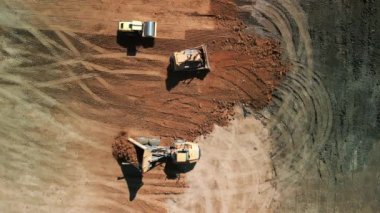 Excavator 'un yukarıdaki görüntüsü maden kamyonuna kum yüklüyor. Madencilik Kazısı, kum kayalarını nakliye kamyonuna yüklüyor. Yüksek kalite 4k görüntü