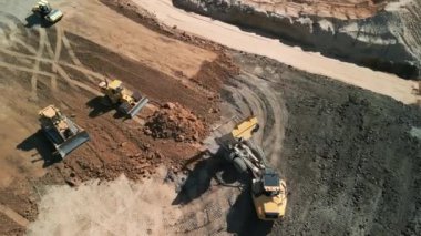 Excavator 'un yukarıdaki görüntüsü maden kamyonuna kum yüklüyor. Madencilik Kazısı, kum kayalarını nakliye kamyonuna yüklüyor. Yüksek kalite 4k görüntü