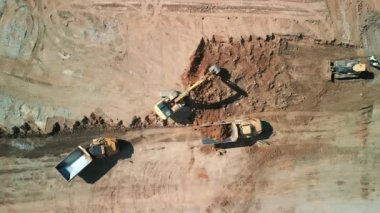 Excavator 'un yukarıdaki görüntüsü maden kamyonuna kum yüklüyor. Madencilik Kazısı, kum kayalarını nakliye kamyonuna yüklüyor. Yüksek kalite 4k görüntü
