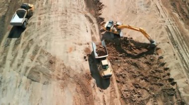 Excavator 'un yukarıdaki görüntüsü maden kamyonuna kum yüklüyor. Madencilik Kazısı, kum kayalarını nakliye kamyonuna yüklüyor. Yüksek kalite 4k görüntü