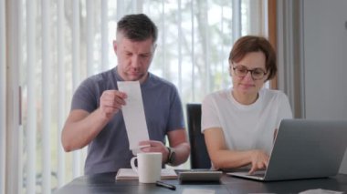 Faturaları, vergileri, banka hesaplarını kontrol eden kadın. Oturma odasındaki ya da ofisteki harcamaları hesaplayan kadın. Yüksek kalite 4k görüntü