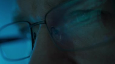 Bilgisayar üzerinde çalışan yazılım mühendisinin portresini kapat. Gözlüklere yansıyan kod kırma hattı. Yüksek kalite 4k görüntü