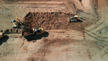 Yukarıdan aşağıya doğru geniş çekim. Bir buldozer, gelişim için bir arazi alanı oluşturur. Yüksek kalite 4k görüntü
