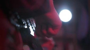 Neşeli genç kızın otururken gitar çalarkenki yakın çekimi. Yüksek kalite 4k görüntü