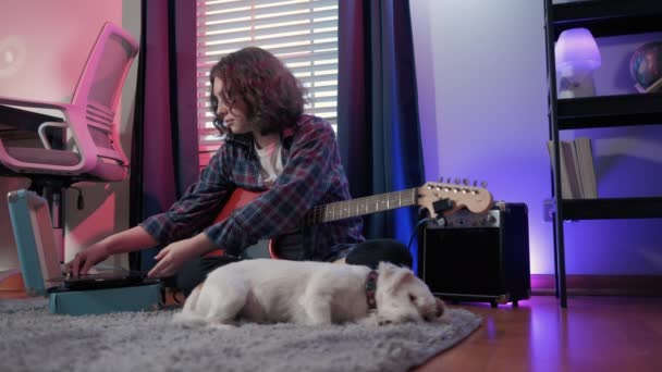犬と座っている間に陽気な女性のティーンエイジャーがギターを演奏します 高品質4K映像 — ストック動画