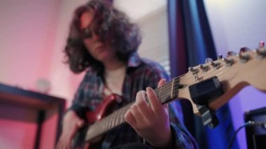 Neşeli genç kızın otururken gitar çalarkenki yakın çekimi. Yüksek kalite 4k görüntü