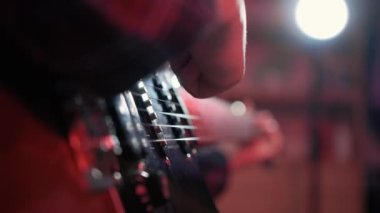Neşeli genç kızın otururken gitar çalarkenki yakın çekimi. Yüksek kalite 4k görüntü