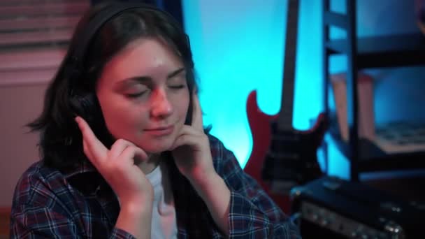 イヤフォンの幸せな若い十代の女性が歌を歌い 音楽を聴く 高品質4K映像 — ストック動画