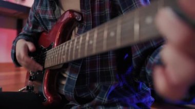 Neşeli genç kızın otururken gitar çalarkenki yakın çekimi. Yüksek kalite 4k görüntü