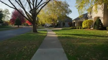 Anne ve kızı güneşli bir günde bir parkta ve banliyö caddesinde bisiklet sürerler. Yüksek kalite 4k görüntü