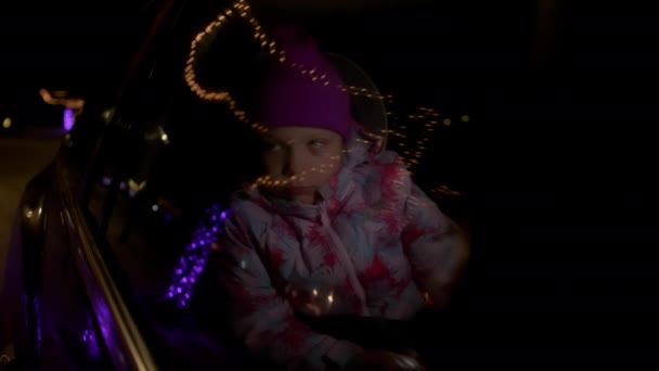 Arabanın Arka Koltuğundaki Gülümseyen Genç Kız Gece Vakti Pencereden Dışarı — Stok video