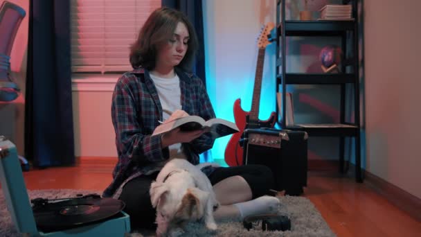 一个与狗坐在一起看书的少女 高质量的4K镜头 — 图库视频影像