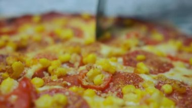Yuvarlak bir bıçakla pizza kesmek. Parçalara ayrılmış. Ağır çekim. Yüksek kalite 4k görüntü