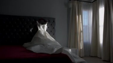 Wedding dress on the bed, in the brides room. Morning of the bride. High quality 4k footage