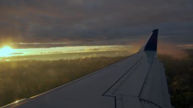 Bulutların üzerinde uçan kanat, yolcu tarafından lomboz deliğinden görüldüğü gibi. Geniş açı. Yüksek kalite 4k görüntü