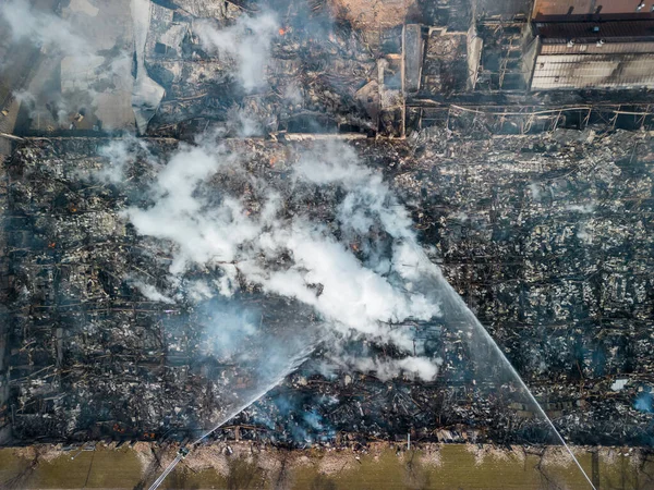 Aerial view of firemen fighting with fire near biulding 