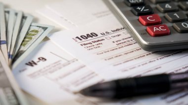 Close up of a 1040 and W9 individual tax form are placed on desk of American citizen. . High quality photo