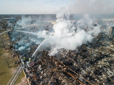 Aerial view of firemen fighting with fire near biulding 