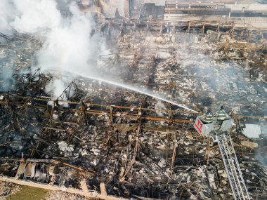 Aerial view of firemen fighting with fire near biulding 