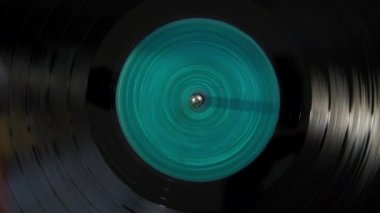 Black vinyl Retro with turquoise color screen in center record on DJ turntable. . High quality 4k footage