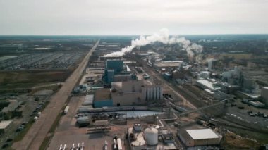 Aerial shot of big factory and smoke comes out chimney of factory plant, polluting environment. . High quality 4k footage