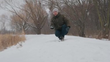 Man playing with jack russell terrier dog in snow in park. happy cheerful . High quality 4k footage