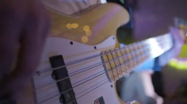 Sahnedeki bir konserde elektro gitar çalan gitariste yakın çekim. Canlı performans. Yüksek kalite 4k görüntü