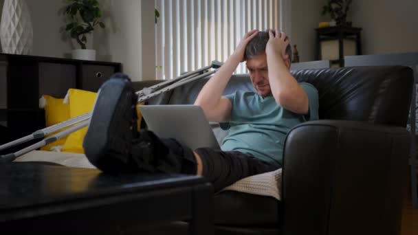 Ein Schmächtiger Mann Mit Gebrochenem Bein Arbeitet Einem Laptop Hochwertiges — Stockvideo