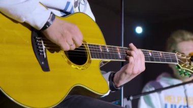 Sahnedeki bir konserde elektro gitar çalan gitariste yakın çekim. Canlı performans. Yüksek kalite 4k görüntü