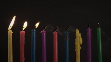 Yanan renkli Hanuka mumları. Şişir ve nefesinle pişir. Yüksek kalite 4k görüntü