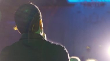 Konser salonunda ışık huzmelerinde şarkı söyleyen bir adam. Yüksek kalite 4k görüntü