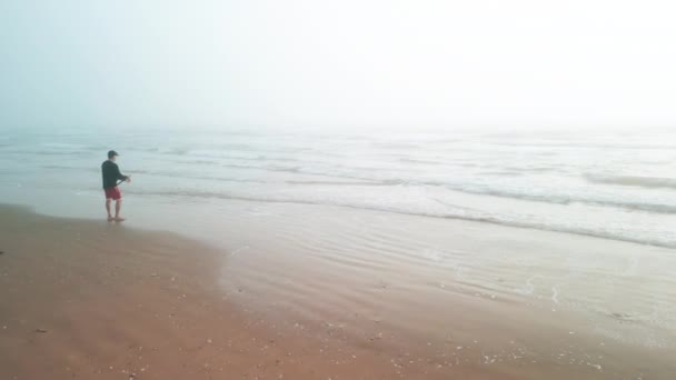 Fisherman Stands Sand Ocean Catches Fish Foggy Morning High Quality — Stock Video