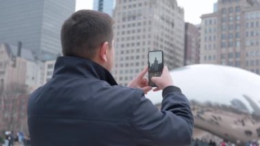 Chicago şehir merkezinde bir adam akıllı telefondan fotoğraf çekiyor. Yüksek kalite 4k görüntü