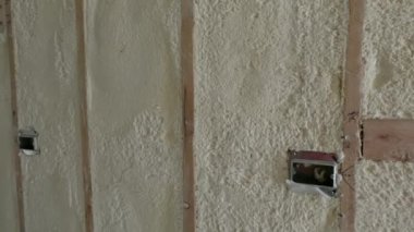 Çevre dostu konut yalıtımı bir evi kaplıyor. Yalıtım malzemesi, yapım aşamasındaki ahşap bir duvarın çerçevesini dolduruyor. Yüksek kalite 4k görüntü