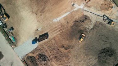 Yukarıdan aşağıya doğru geniş çekim. Bir buldozer, gelişim için bir arazi alanı oluşturur. Yüksek kalite 4k görüntü