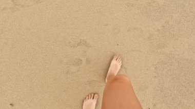 POV bakış açısına göre genç bir kadın kumsalda kuma adım atıyor. - Evet. Yüksek kalite 4k görüntü