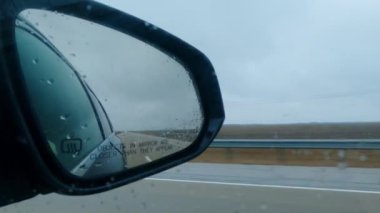 Yağmurlu bir günde otoyolda hareket eden bir arabanın aynası. Yüksek kalite 4k görüntü